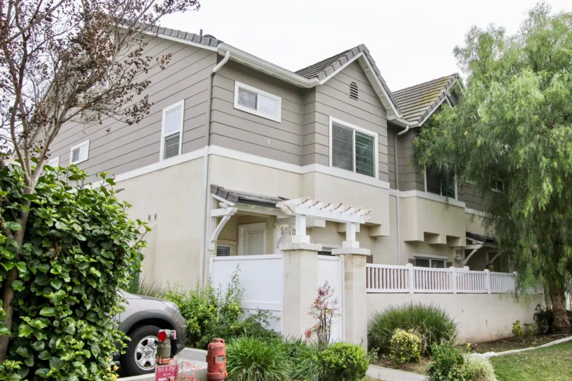 THIS IMAGE SHOWS THE SIDE VIEW OF THE HOUSE WITH PLANTS AND TREES, CAR, LAWN LOCATED IN BUENA PARK CITY