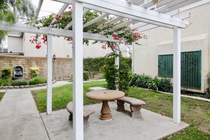 A small shelter in the Trellis Lane with a table and chairs.