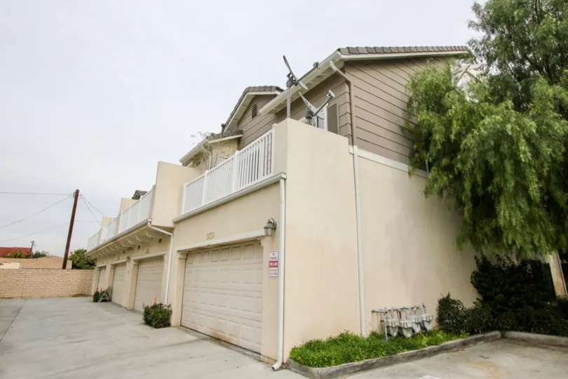 A side view of a building in the Trellis Lane with a tree.
