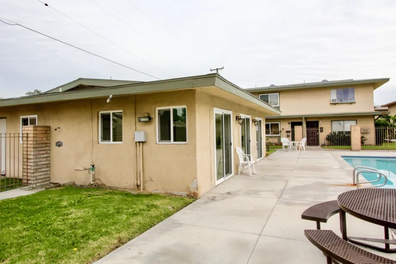 THIS IMAGE SHOWS THE HOME WITH SWIMMING POOL, CHAIRS, LAWN ARE LOCATED IN BUENA PARK CITY