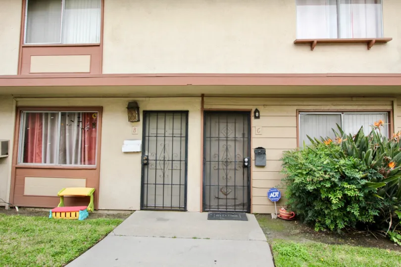 THE FRONT VIEW OF THE HOUSE WITH NAMED ON THE WALL NEARBY PLANTS WITH FLOWERS ARE LOCATED IN BUENA PARK