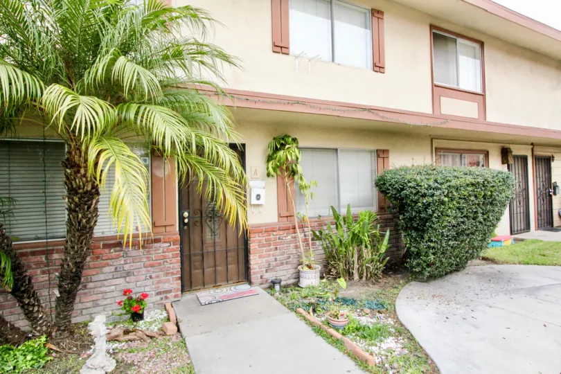 THE FRONT VIEW OF THE HOUSE WITH PLANTS, TREES PATHWAY LOCATED IN BUENA PARK