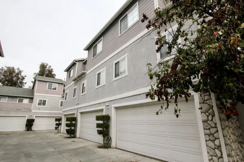 a pleasant day in the western bay estates with a building that has 4 parking door closed and garden in front