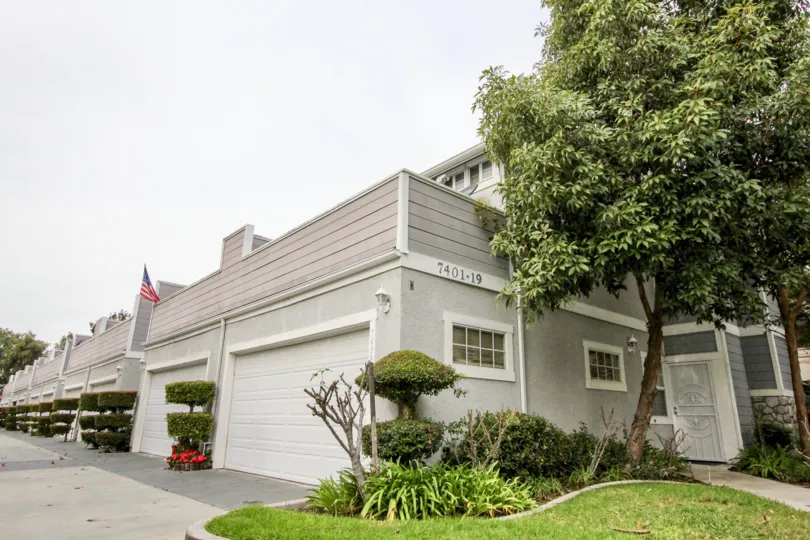 THE 7401-19 APARTMENT IN THE BAY ESTATES WITH THE SHUTTERS, FLAG, LAWN, PLANTS, TREES