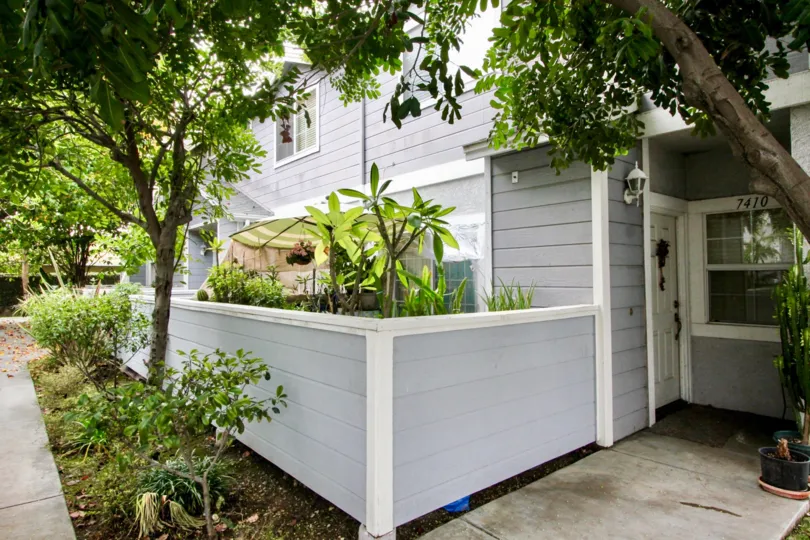 THE FRONT VIEW OF HOUSE WITH NUMBER ON THE WALL WITH LOT OF TREES, PLANTS WHICH IS LOCATED IN BUENA PARK