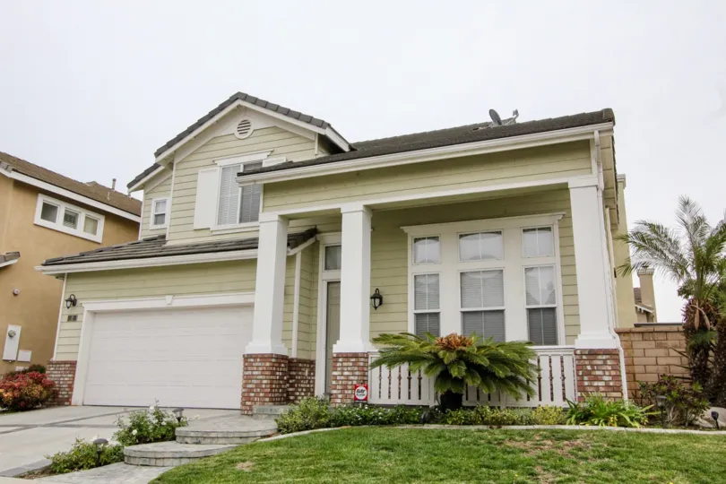 THE FRONT VIEW OF THE HOME IN BUENA PARK WHICH HAVE THE BEAUTIFUL LAWN, CROTON PLANTS ARE THERE