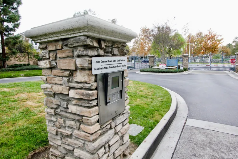 In Westshore Villas, Stop sign board is present near the gate with trees and meadows