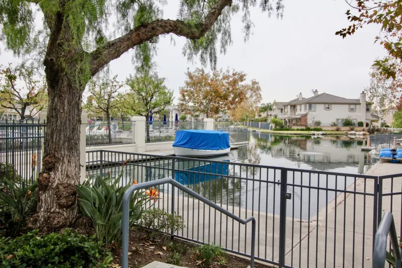 THIS IMAGE SHOWS LAKE SURROUNDING MANY TREES, PLANTS ARE VISIBLE LOCATED IN BUENA PARK