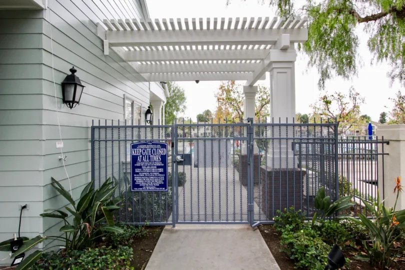 A gate in the Westshore Villas with a blue sign board.
