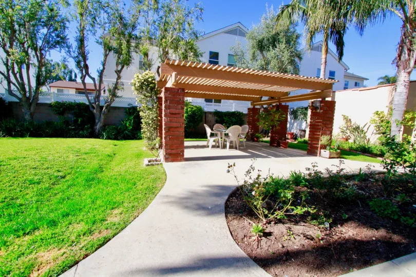 A nice backyard area with a table under an outting in Alta Mesa community.