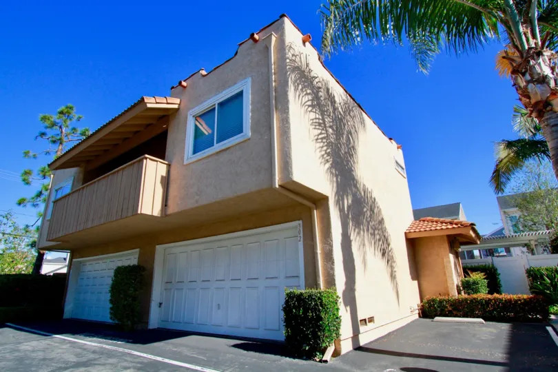 Alta Mesa apartments with a balcony and garage on a sunny day.