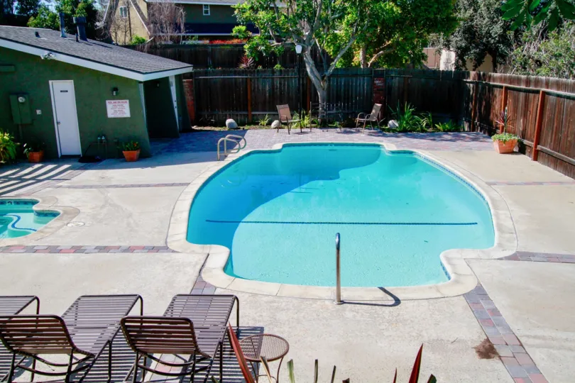 The home in the Back Bay Village Sunrise is like a restaurant with lots of trees, plants and swimming pool with chairs.