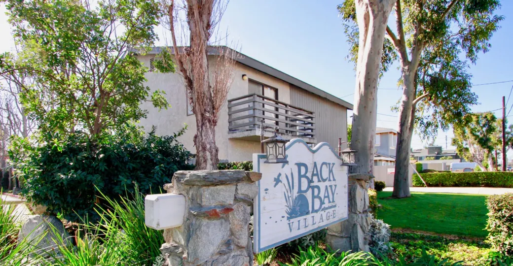 The house in the Back Bay village  is very beautyful with trees and plants and also with lawn, name board.