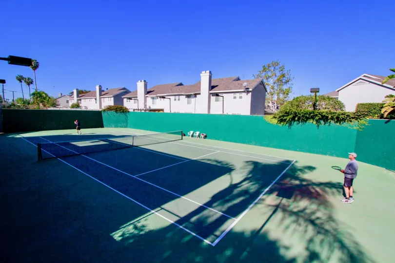 Bay View Terrace tennis courts with a fence and net on a sunny day.