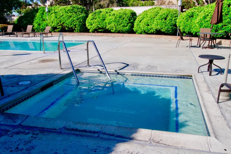 A sunny day in the Brookview city with swimming pool, chair and tables and also with green plants.