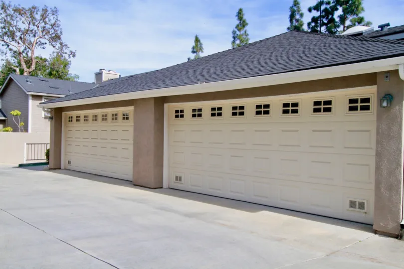 Canyon Walk garages with a fence and trees on a sunny day.