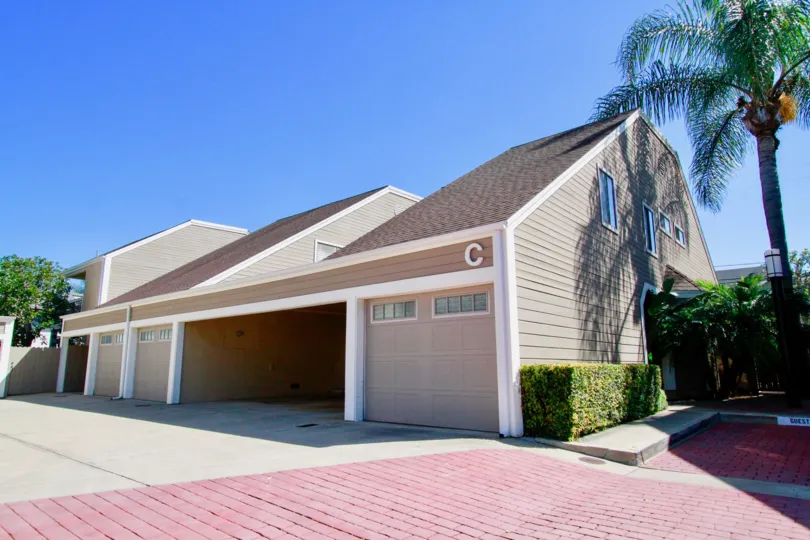 Cedar Glen Townhomes garages with trees and bushes on a sunny day.