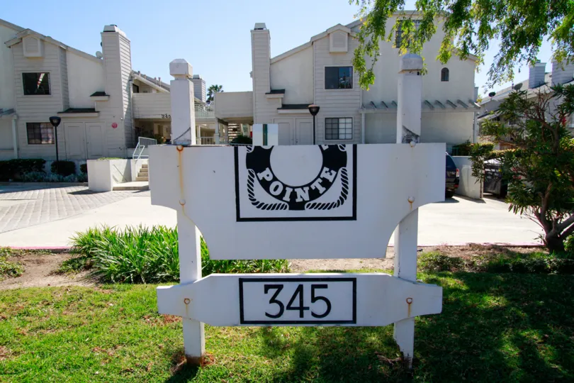 A sunny day inthe Coral Point with houses, trees, plants, street board and clean streets.