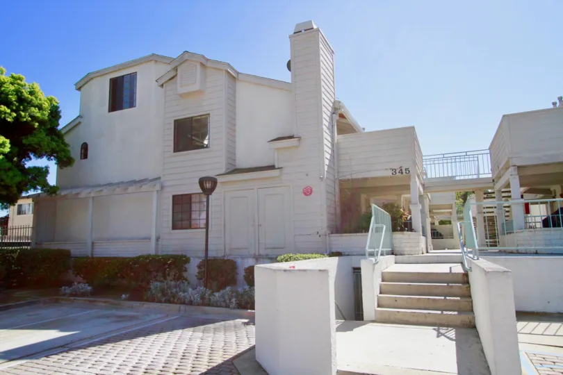 Coral Point apartments with a staircase and street lamp on a sunny day.