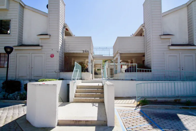Coral Point apartments with a staircase and street lamp on a sunny day.