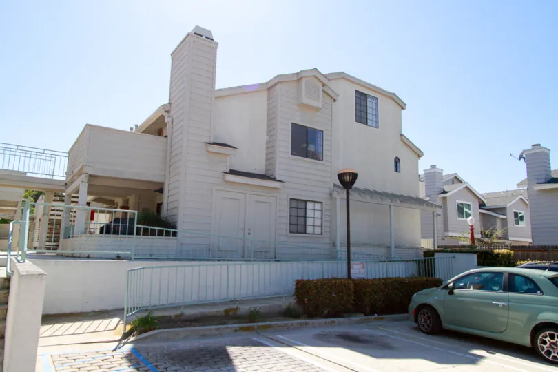 Coral Point Costa Mesa California building shadow falls in front of car and gate