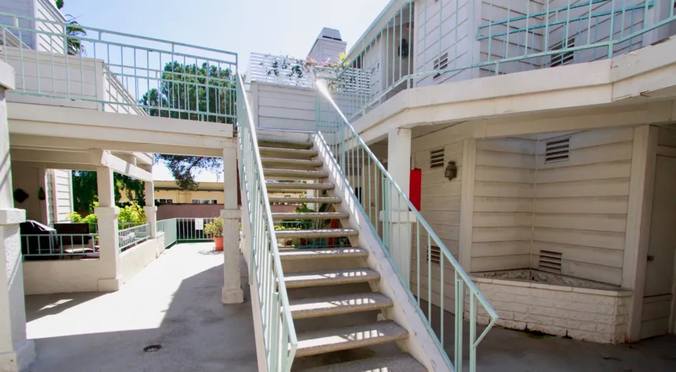 THE STEPS AT THE CENTRE WENT TO THE BOTH SIDE AND MORE HOUSES ALSO AVAILABLE AT THE APARTMENTS AND IT LOOKIS LIKE MILD COLOUR AND SOME PLANTS ALSO AVAILABLE AT THE BACKSIDE OF THE PLACE
