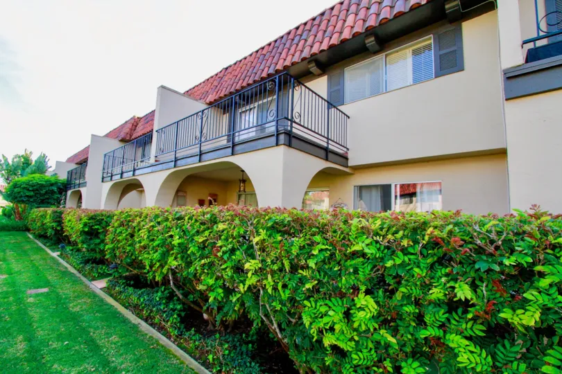 Country Club Villas apartments with balconies and bushes on a cloudy day.