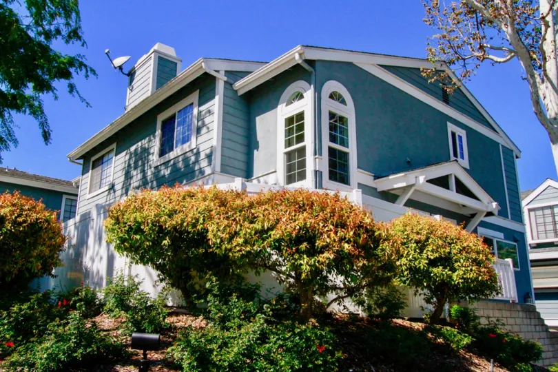 THE BUILDING WITH GOOD LOOKING BLUE COLOR AND THE TREES ALSO FRONT OF THE HOUSE AND THE DISH LOCATED AT THE ROOF OF THE BUILDING AT THE MORNING TIME.