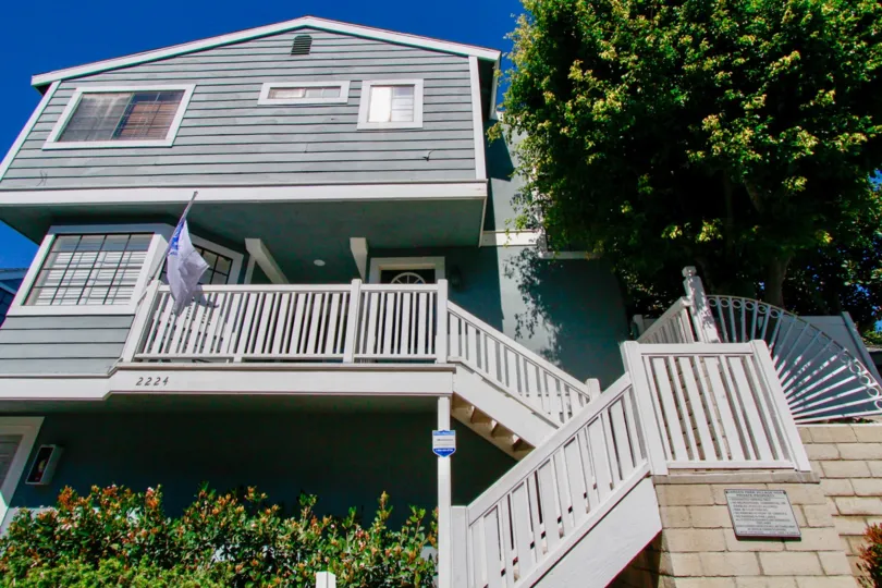 Garden Park Village home with a flag and staircase on a sunny day.