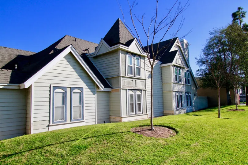 Knowleton Manor apartments with trees and a lawn on a sunny day.