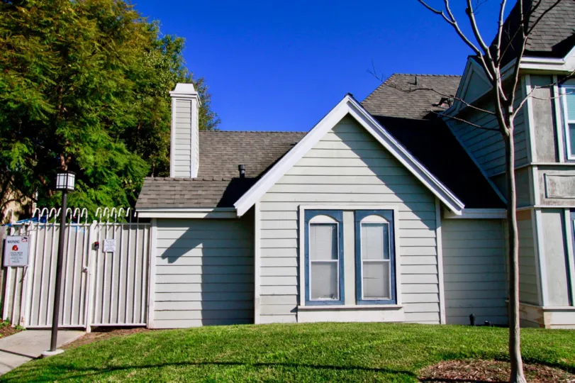 : Knowleton Manor Costa Mesa California building white color paint triangle shape near tree and grasses leafless tree