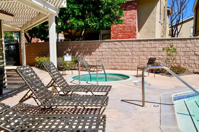 A SMALL KID POOL WITH TWO SITTING CHAIRS AND A ROOF NEAR TO THE PLACE AND SOME TREES ALSO AVALIABLE AT THE MORNING TIME.