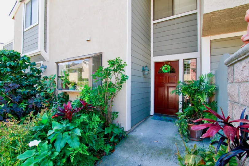 Laurel Point apartment building with a brown door and plants on either side.