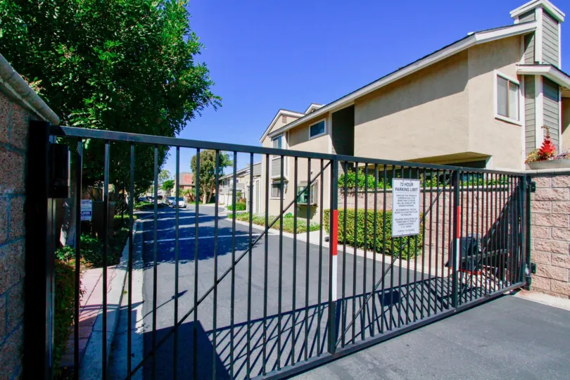 THE FRONT GATE CLOSED AND THE APARTMENTS ALSO INSIDE THE GATES AND SOME TREES ALSO AVAILABLE AT THE MORNING SUNSHINE TIME.