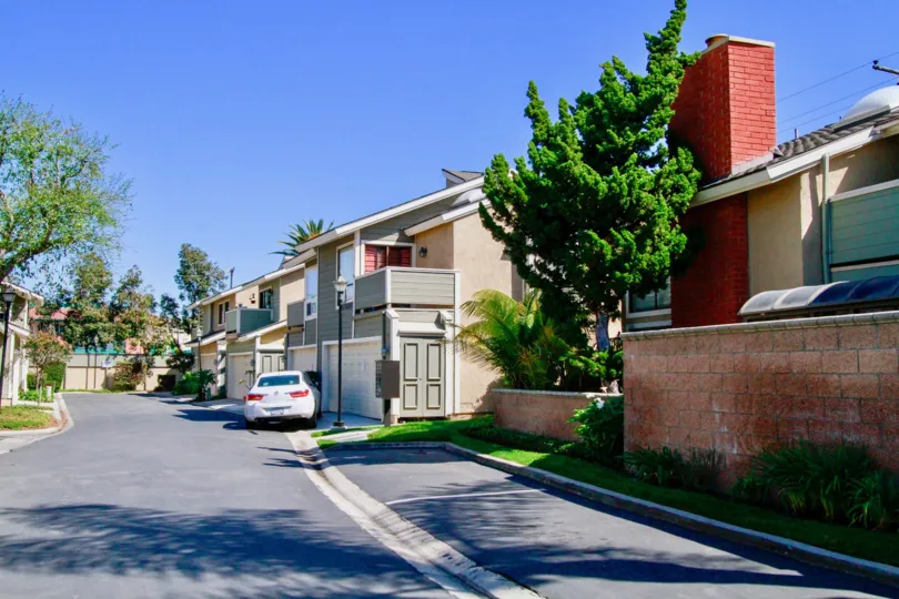 Laurel Point street with apartment buildings and a car on a sunny day.