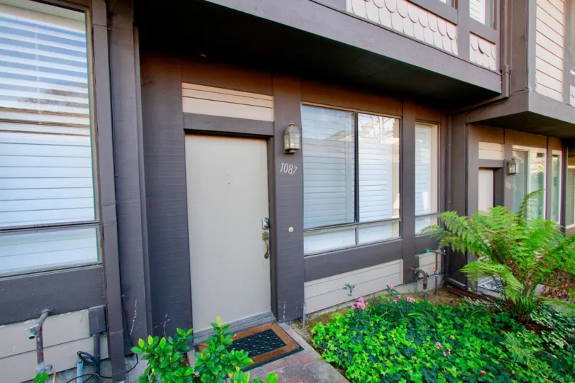 A Mesa Bluffs building with windows, bushes, and other plants.