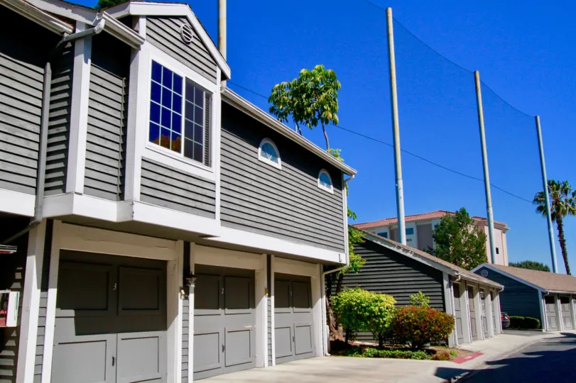 Newport Landing apartments with garages and power lines on a sunny day.