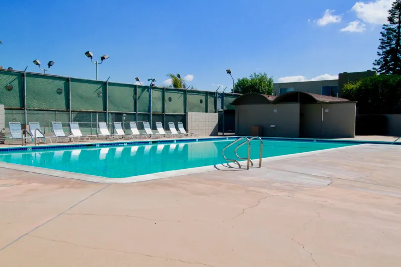 Newport Riviera pool with a deck chair and a fence on a sunny day.