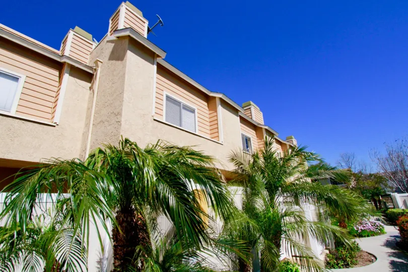 Ocean Breeze Villas apartments with a fence and palm trees.