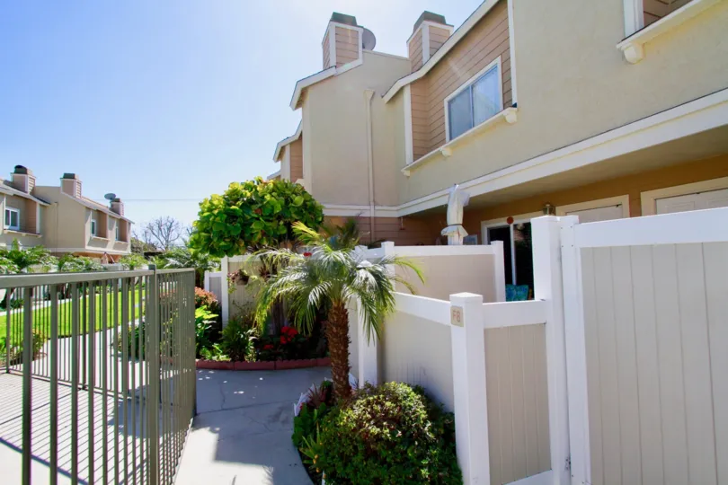 Ocean Breeze Villas apartments with a fence and gate on a sunny day.