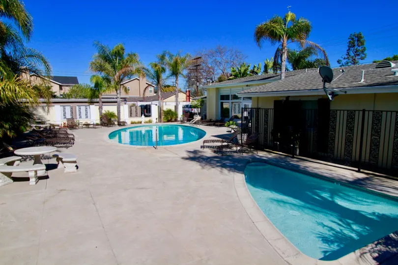 Community pool, kids pool and large outdoor space on a sunny day in the Orleans Townhouse community in Costa Mesa, CA
