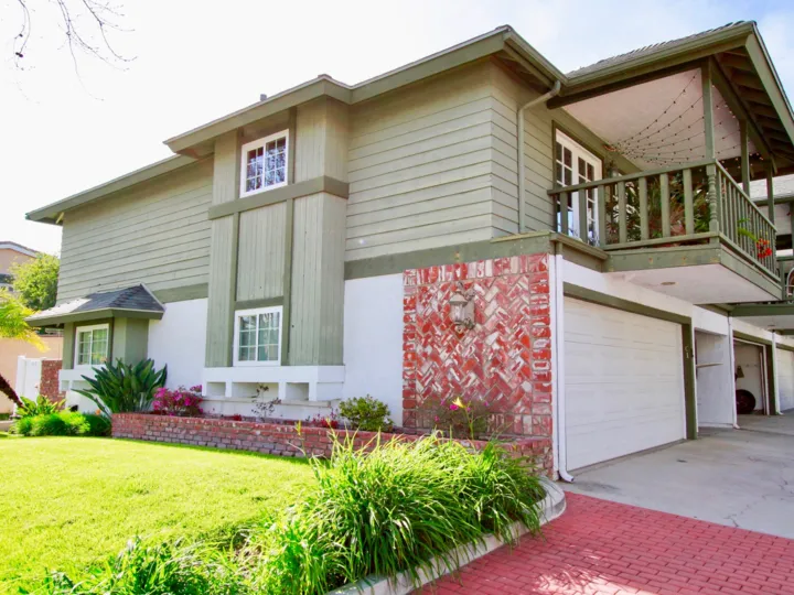 A beautiful home in the Pacific Bluffs is like a villa house with lawn, trees and plants.