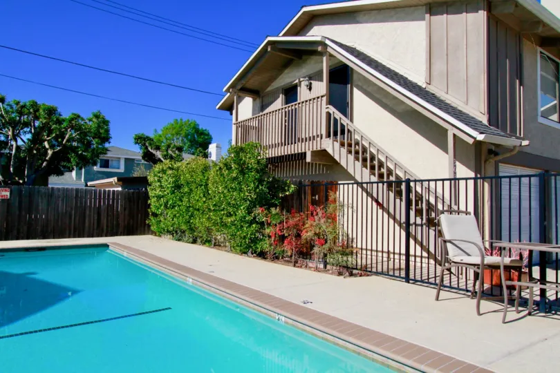 Pool of Peppertree Heights with a deck chair and fence on a sunny day.