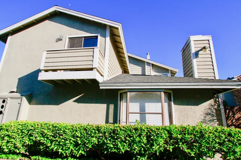 Modern, grey home, featuring balcony, high chimney, privacy hedges, picture window, Quiet Bay Townhomes, Costa Mesa, California