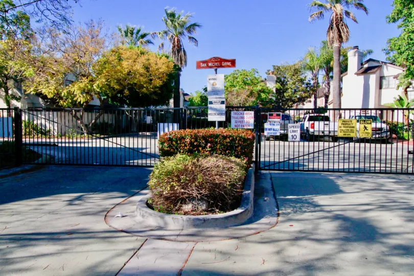 Entrance to San Michel with bushes and palm trees on a sunny day.