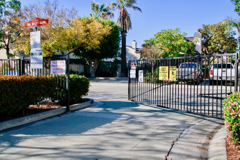 THE ENTRANCE GATE OPENED ANS TWO TO THREE SIGN BOARDS ALSO PLACED INSIDE THE GATE AND SOME CARS ALSO PARKING AT THE PARKING PLACE SOME TREES ALSO AVAILABLE.