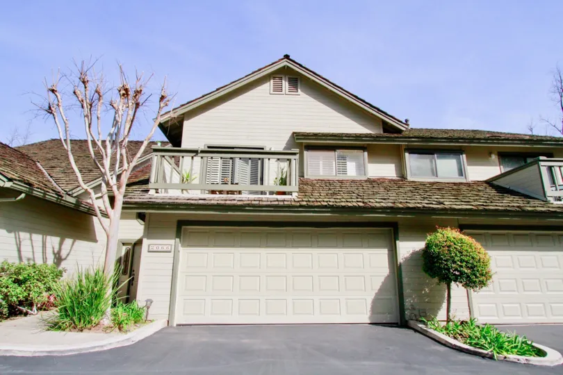 Seabluff Canyon Costa Mesa California bulding near to one leafless tree another side one small tree house fully light white color paint attached