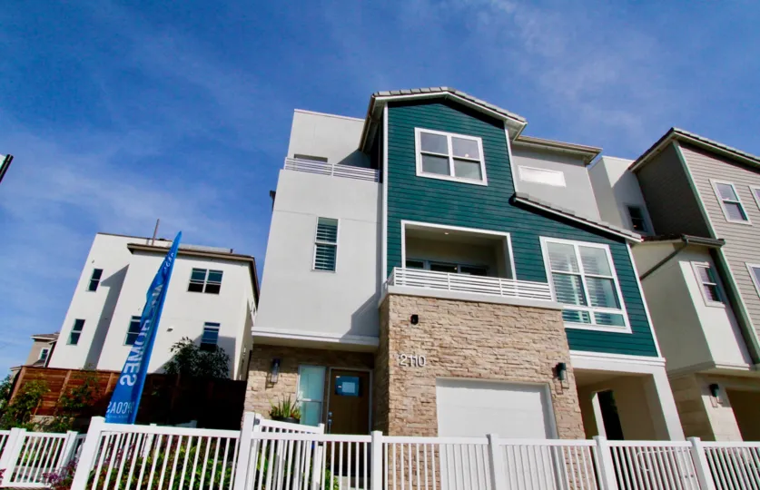 Brick, wood facade of Seabreeze apartments, featuring privacy fence, Costa Mesa, California