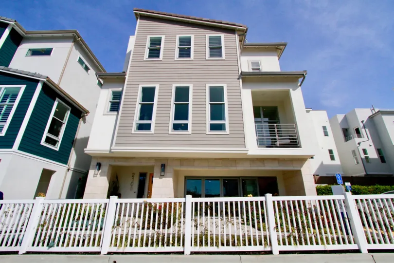 Seabreeze apartments with a white fence on a sunny day.