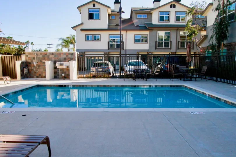 Seabright pool with a fence and deck chairs on a sunny day.